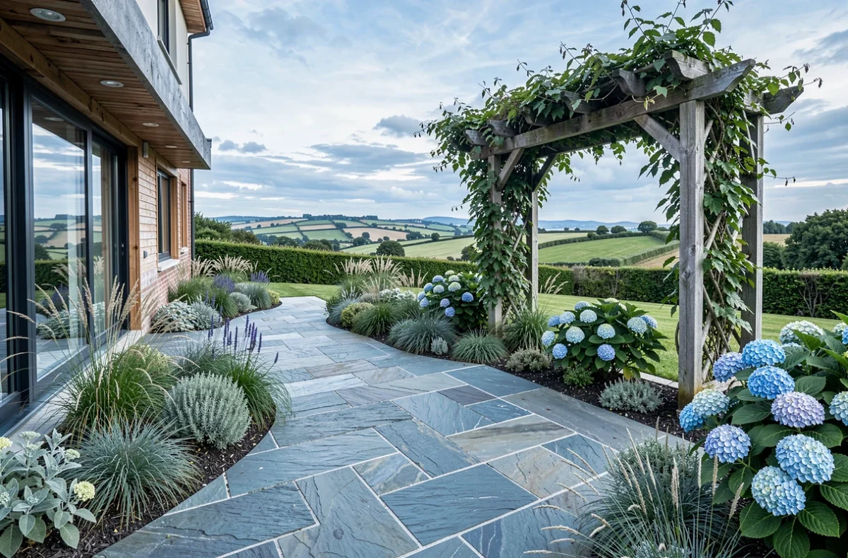 Terrasse de jardin côtier aménagée par Emeraude Jardins avec des dalles en schiste et des plantes adaptées au littoral breton